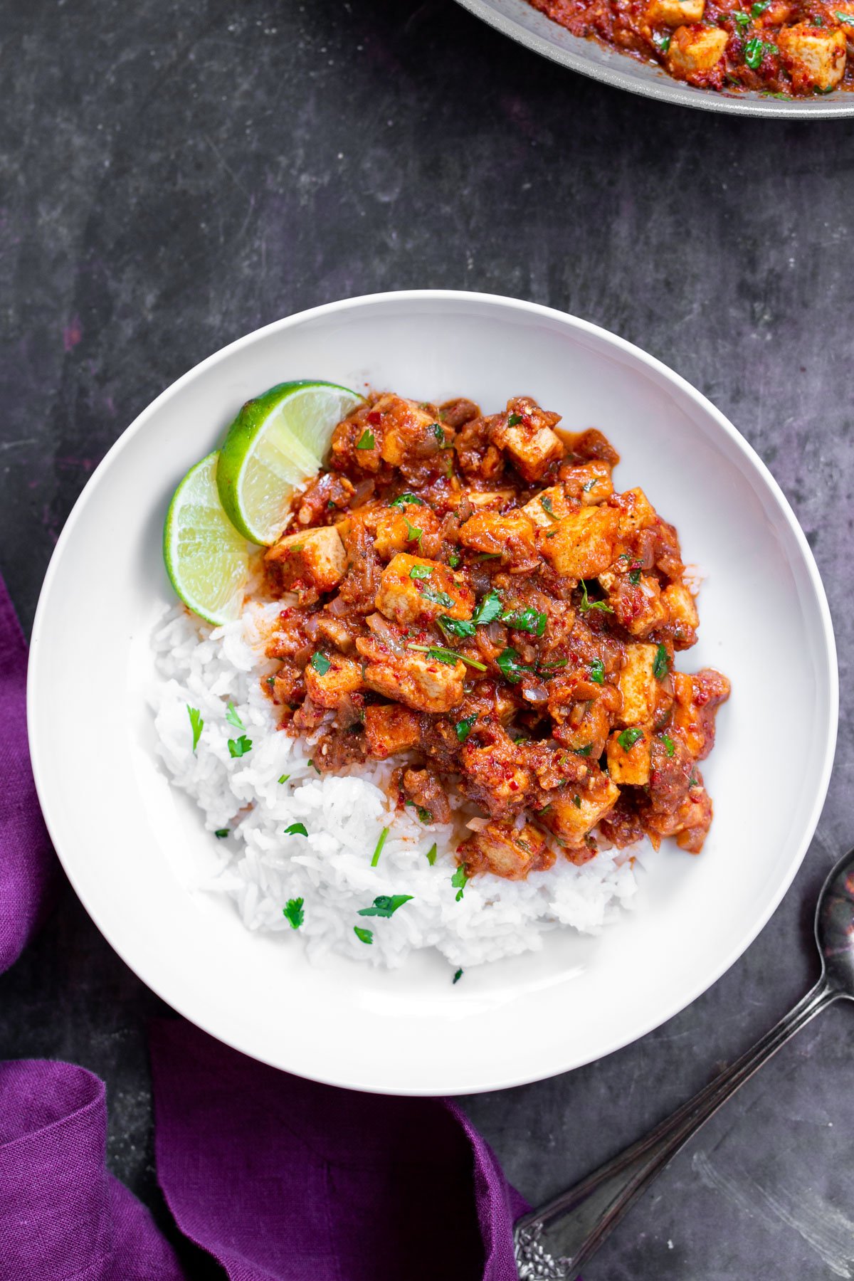 tofu vindaloo tofu vindaloo on a plate served with rice and lime slices