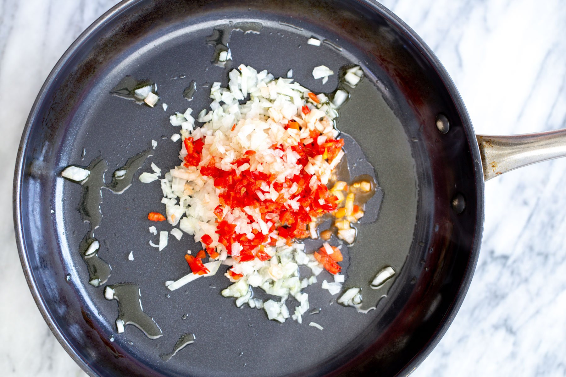 minced red chili garlic and onion in a sauteeing pan