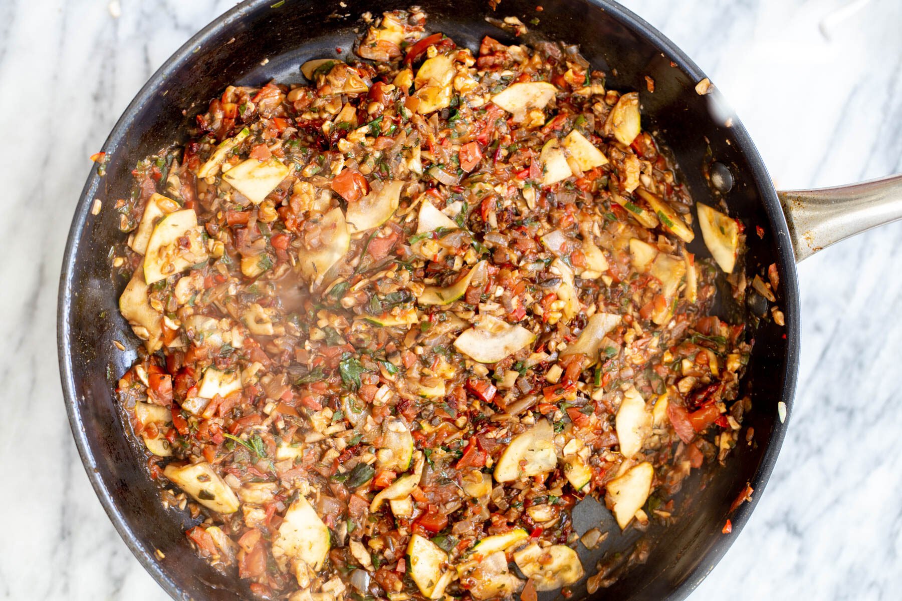 veggies stir-frying in a black sauteeing pan