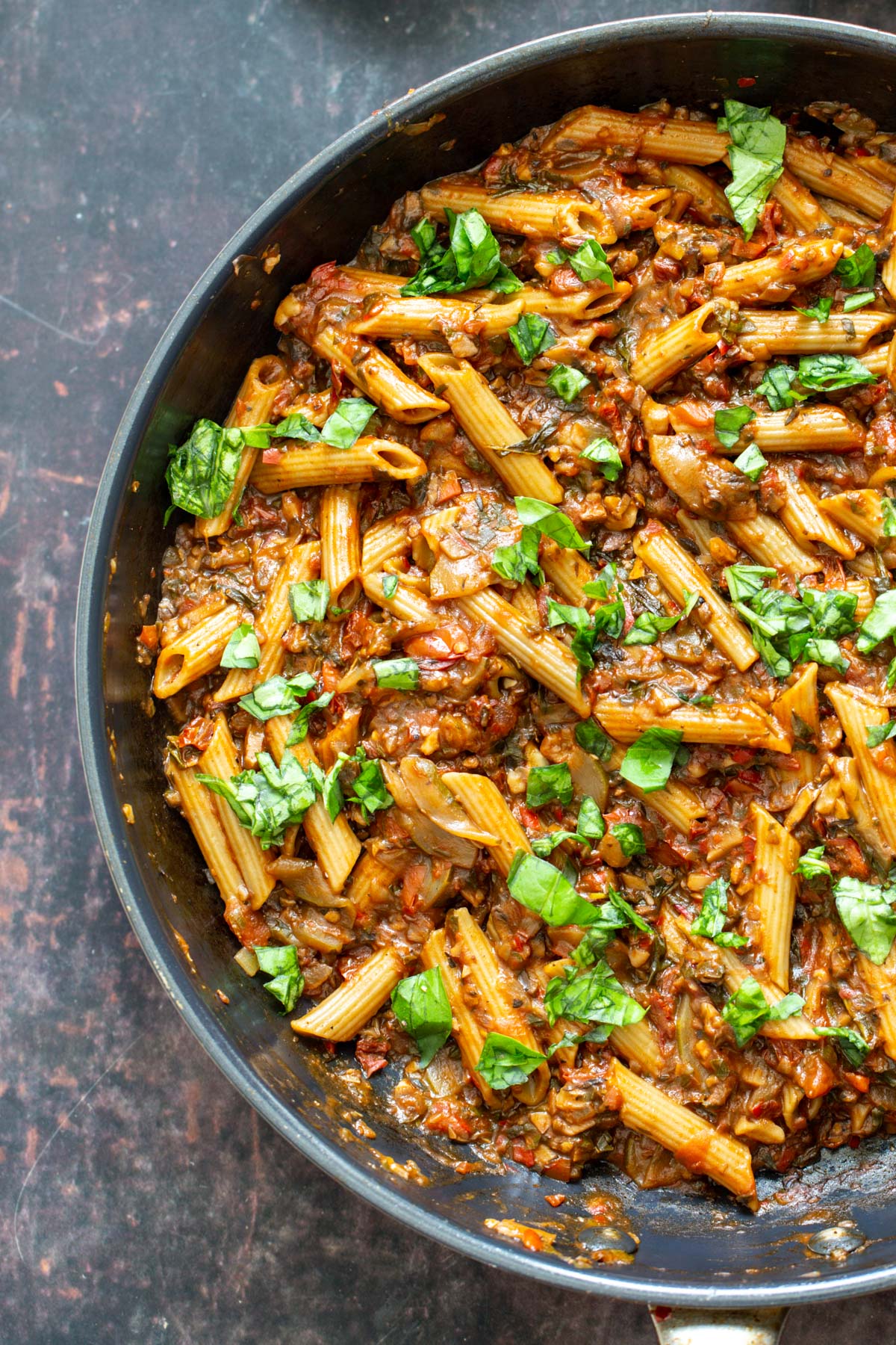 veggie pasta with walnuts, sun-dried tomatoes and basil in a pan