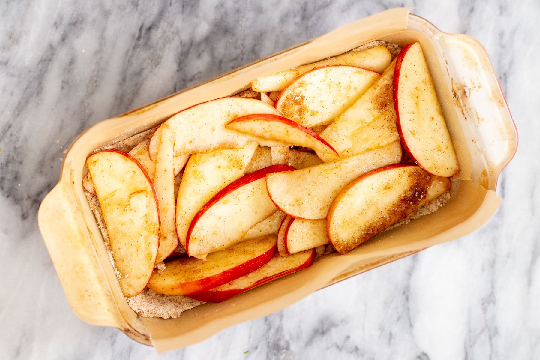 apple slices being added to crust to make vegan apple pie cars