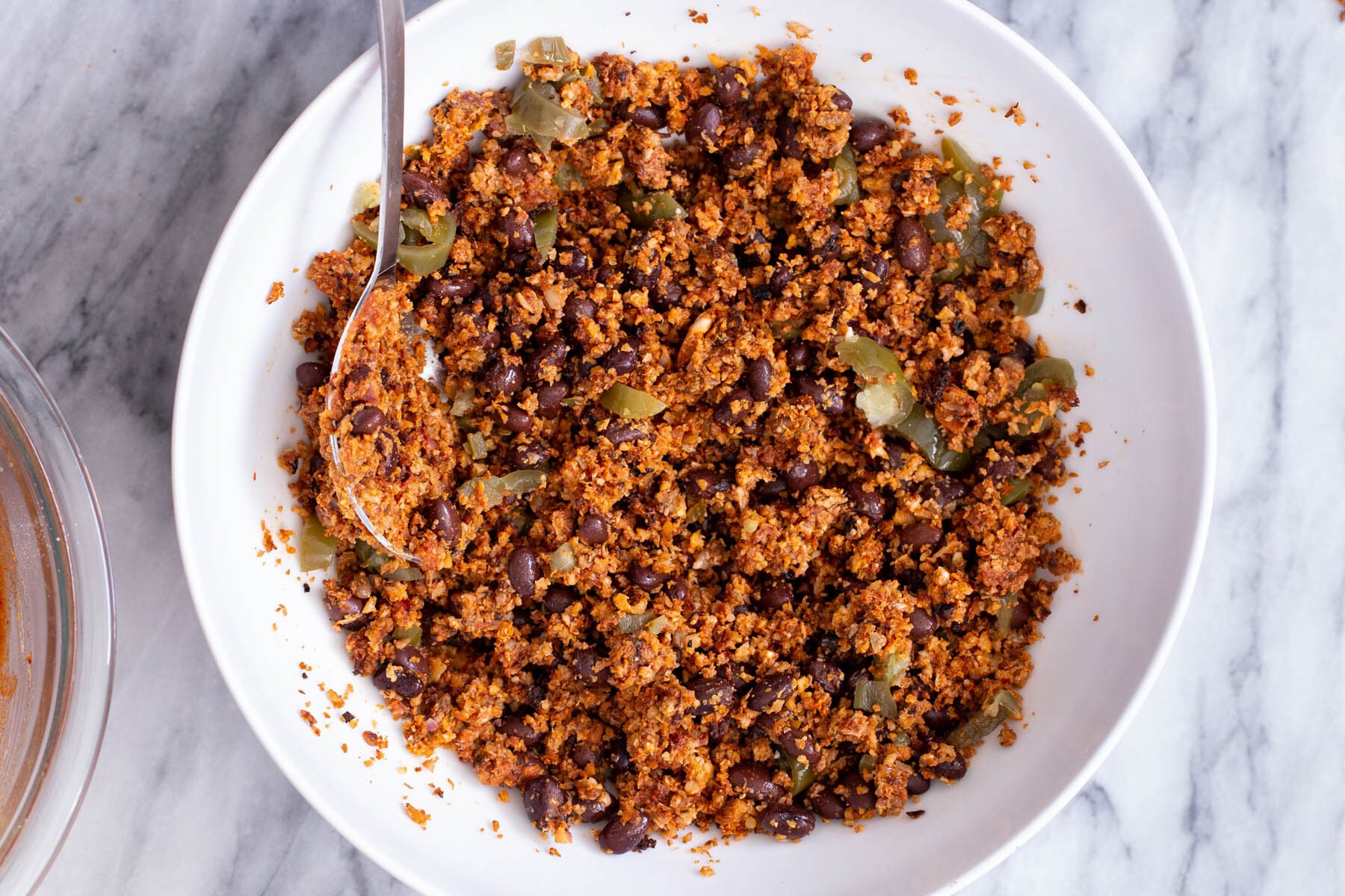 beans and green chilies being mixed into cauliflower taco meat