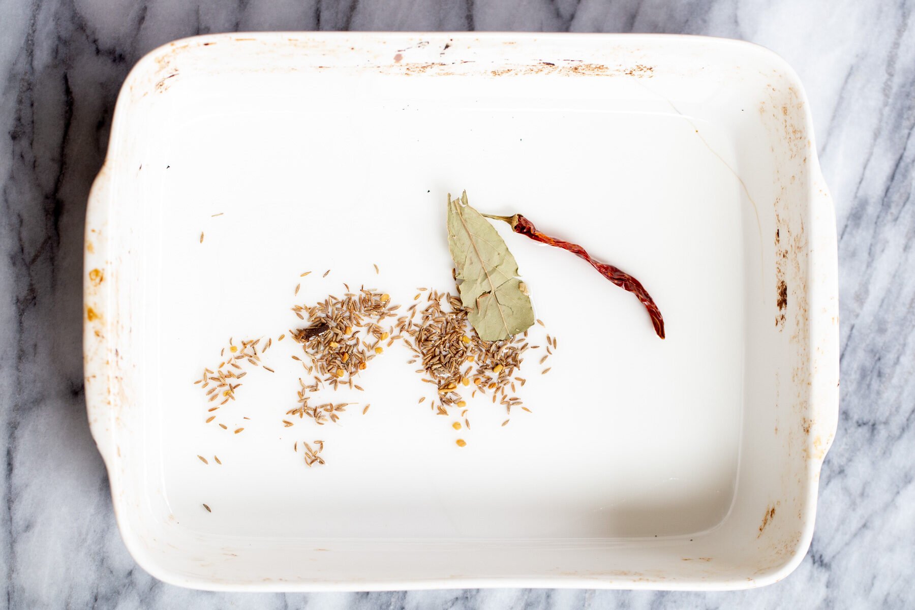 dried spices in a white casserole dish