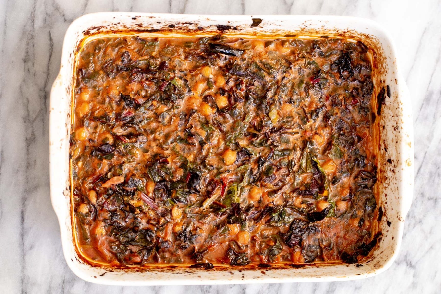 baked chana saag in a white casserole dish