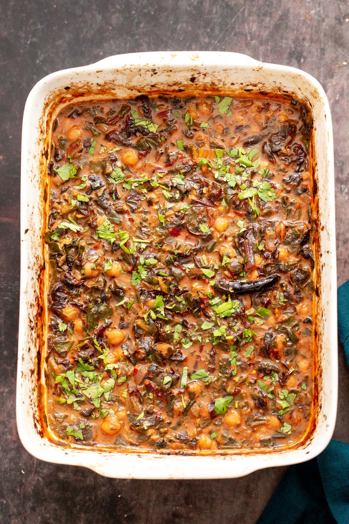 overhead shot of a vegan Indian chickpea spinach casserole in a white casserole dish