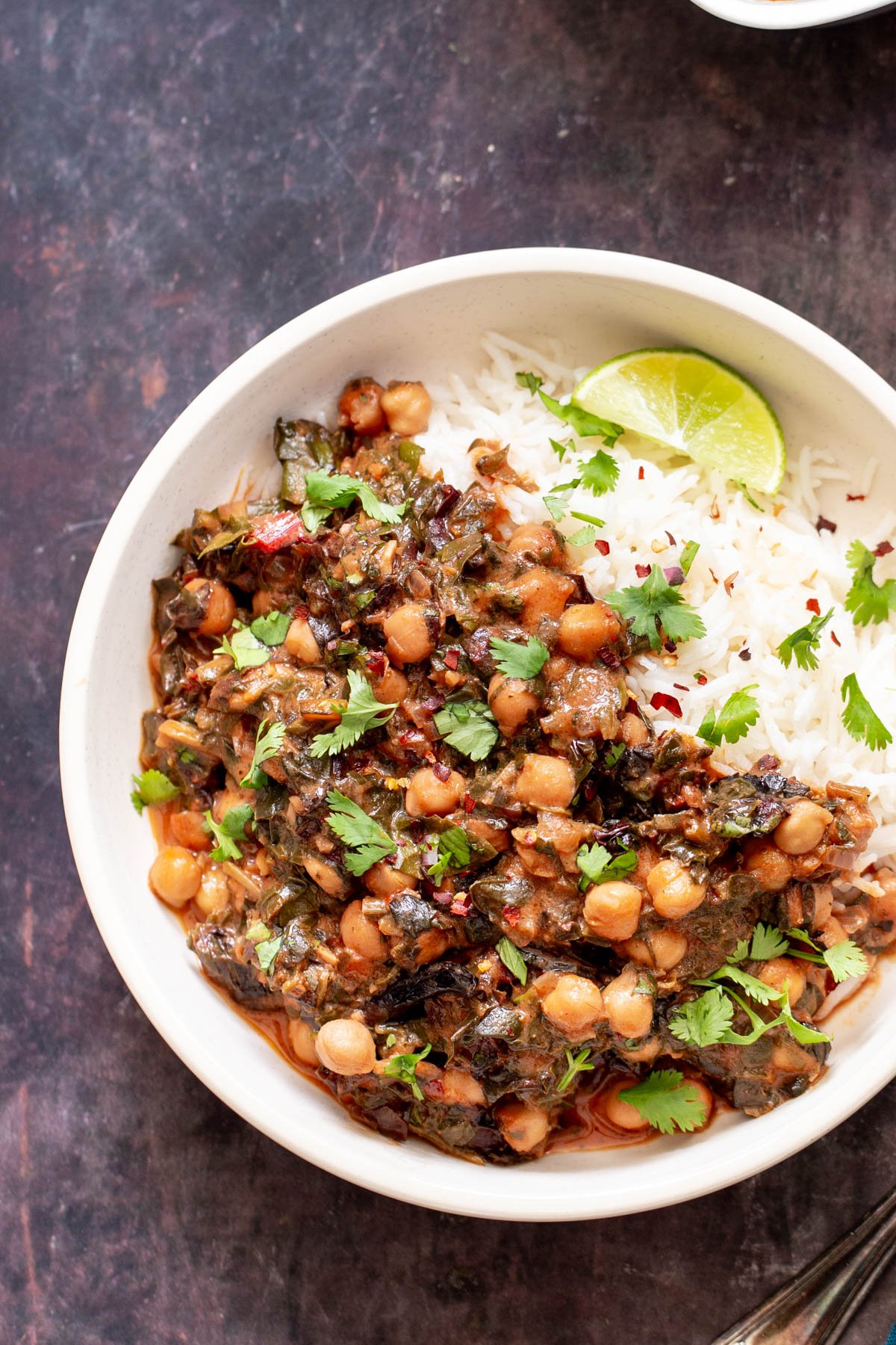 a plate of vegan chickpea spinach curry served over rice
