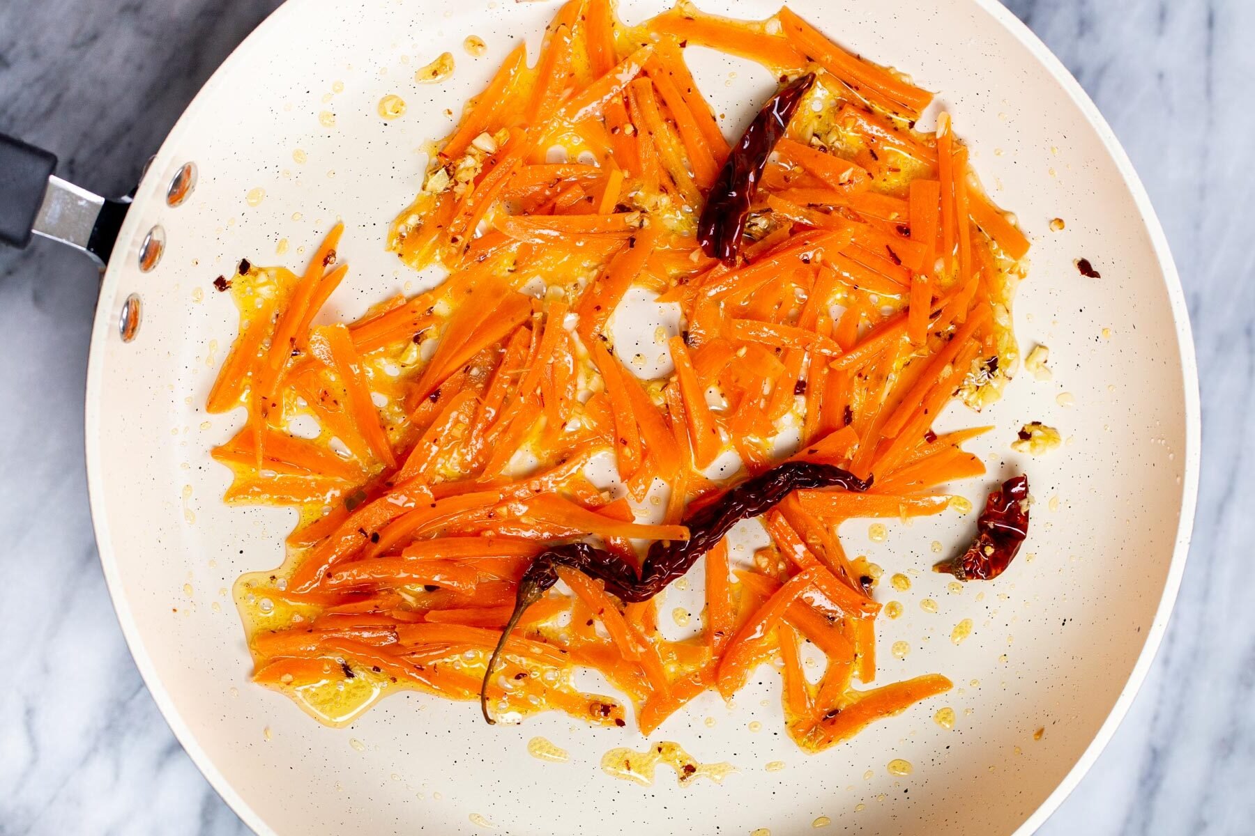 stir-fried grated carrots in a white pan