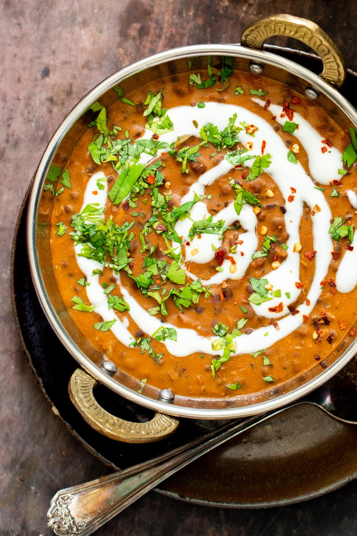a platter of dal bukhara drizzled with vegan cream and sprinkled with cilantro