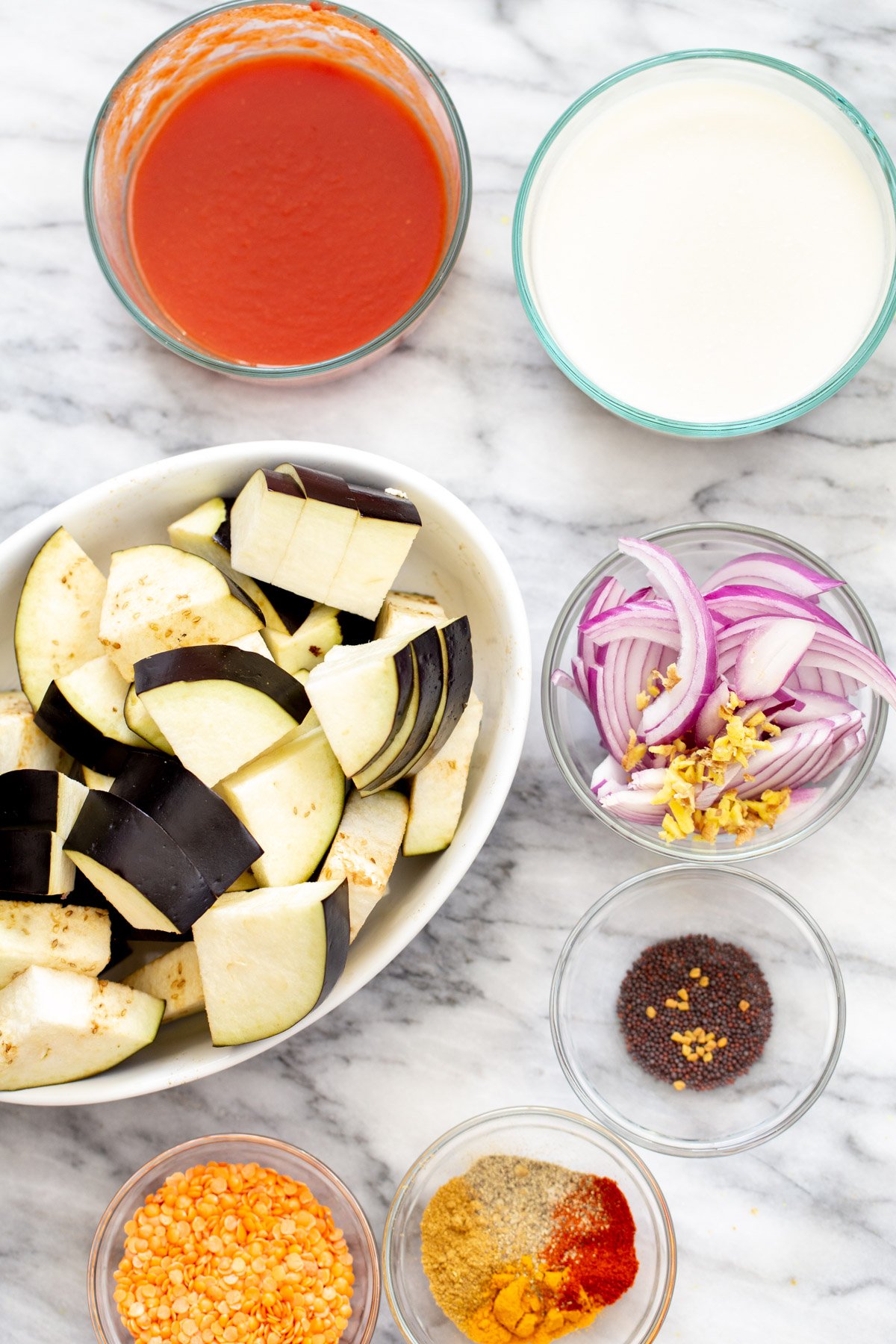 ingredients for baked eggplant curry recipe on a marble countertop