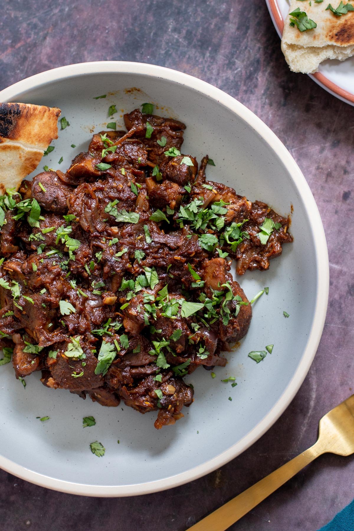ethiopian mushroom tibs Ethiopian mushroom tibs stir-fry served with a side of bread on a pale blue plate