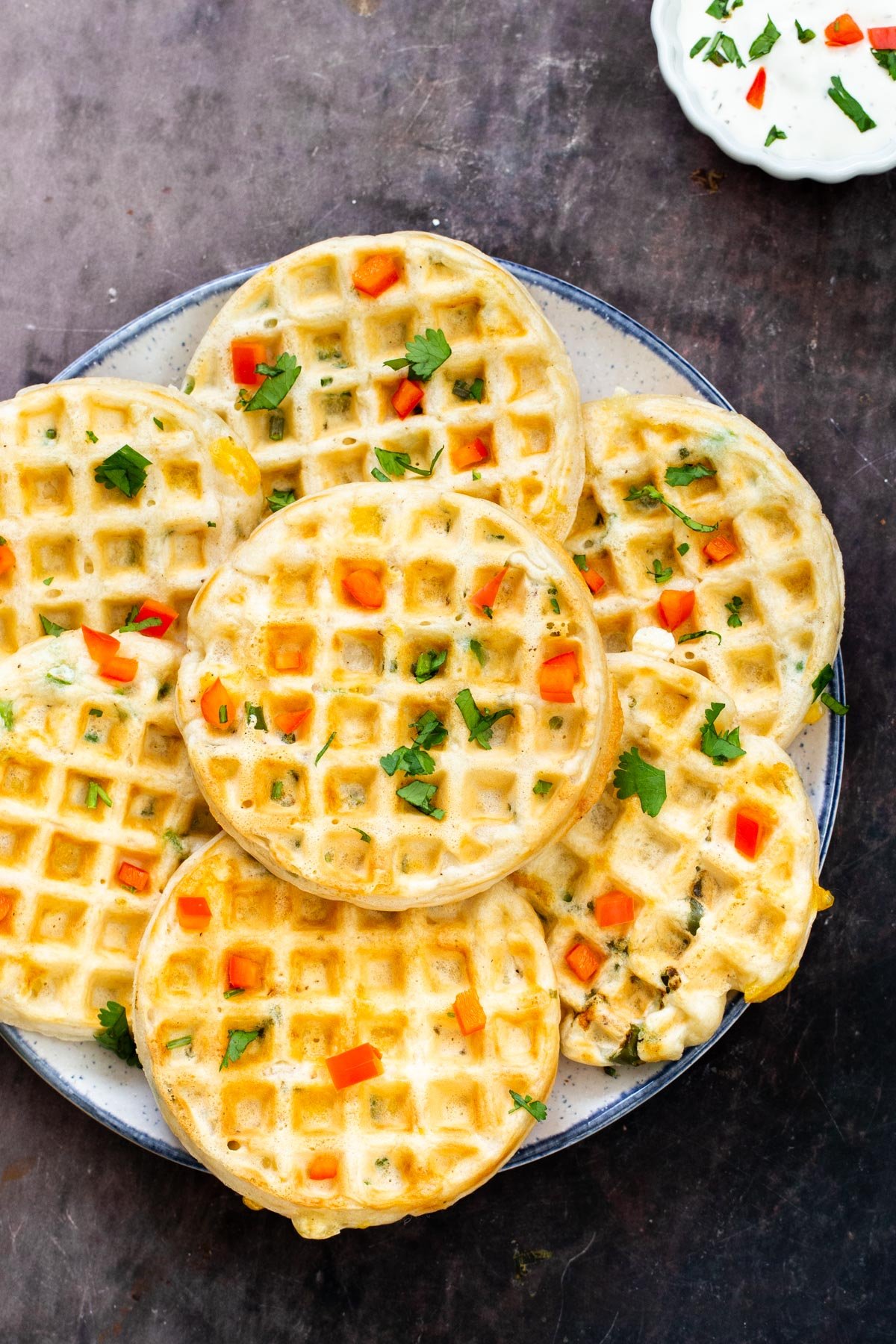 a plate of small vegan cheddar jalapeno waffles on a plate