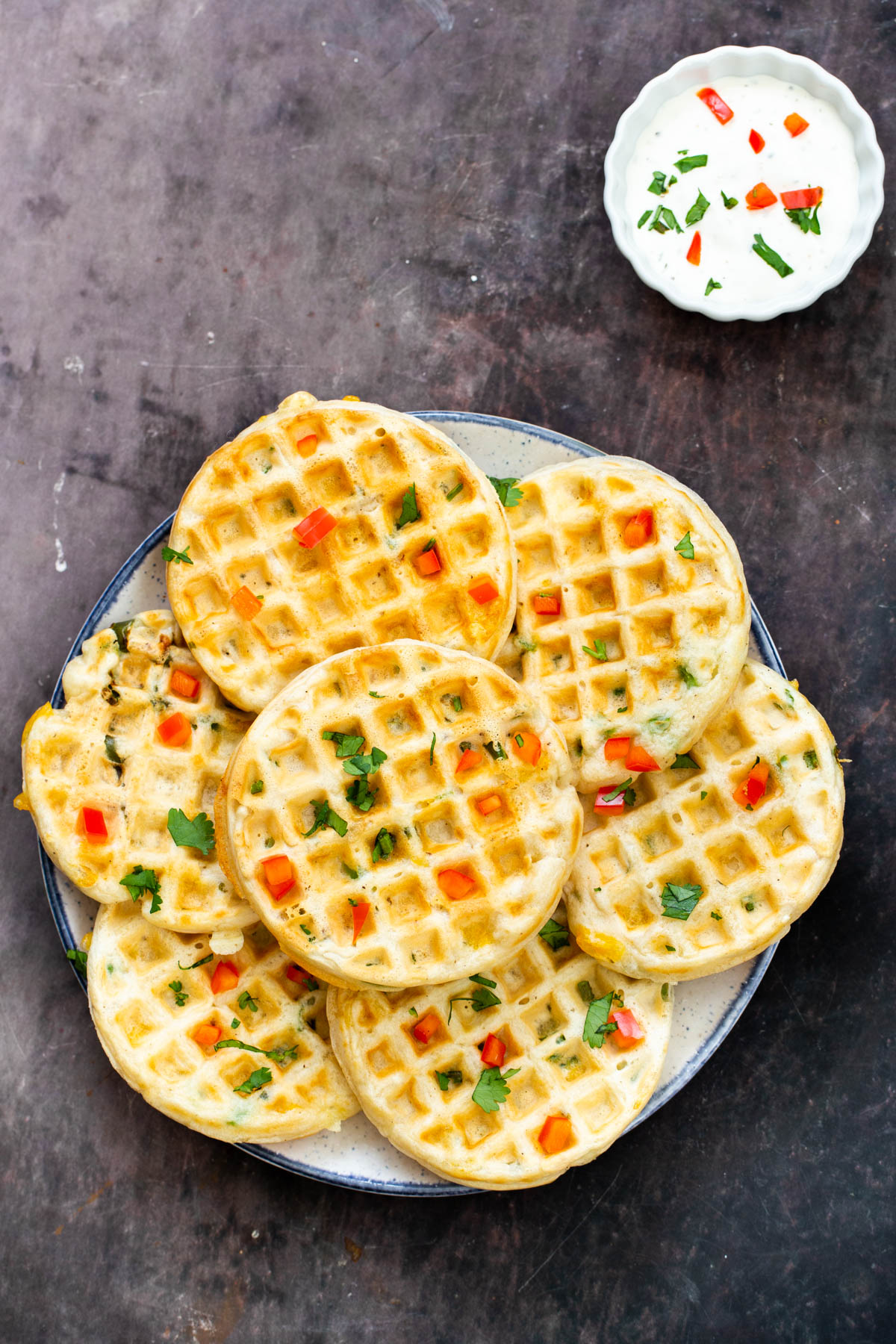 a plate of vegan cheddar jalapeno waffles with a side of sour cream