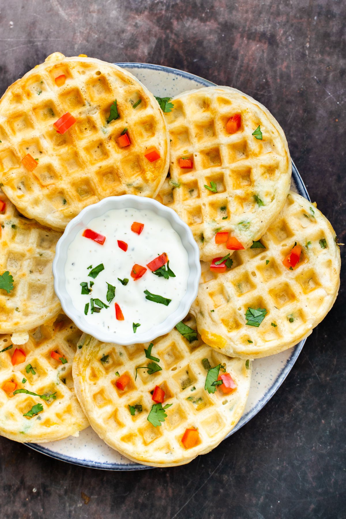 a plate of vegan jalapeno waffles with a small dish of vegan sour cream