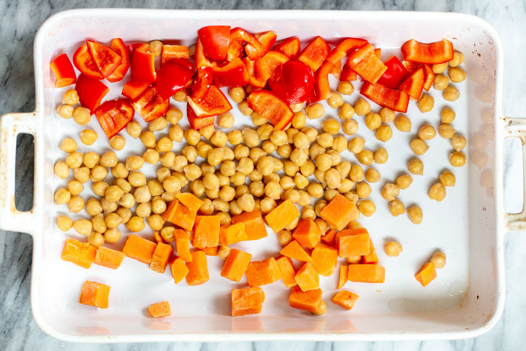 chickpeas bell peppers and squash in a casserole dish
