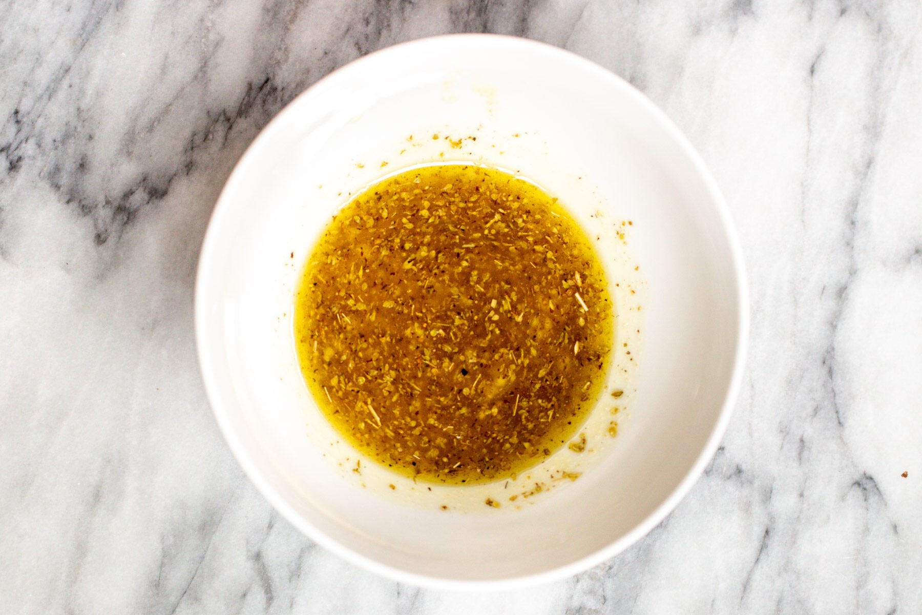 Mediterranean dressing in a small white dish