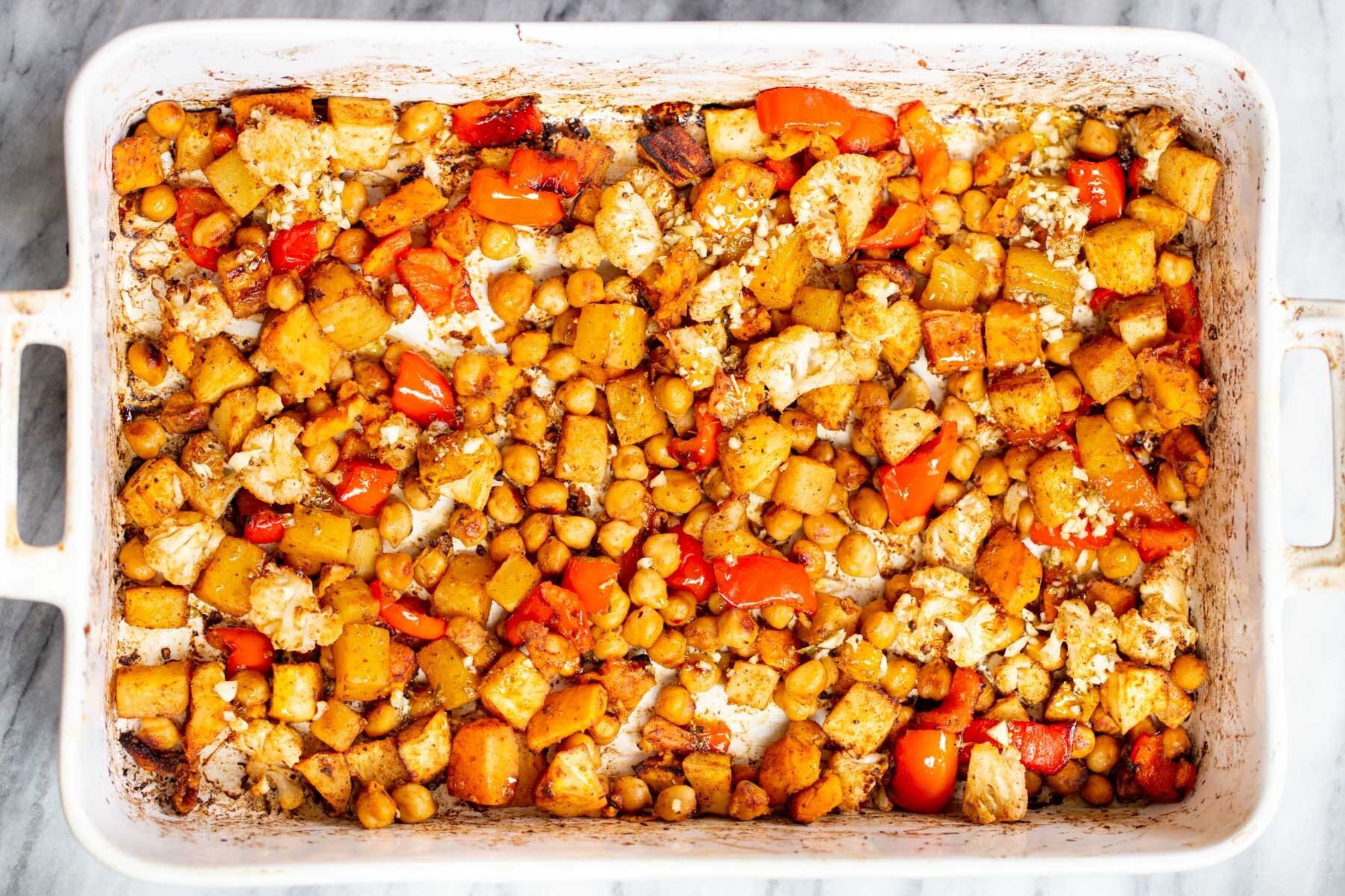 balsamic roasted chickpeas and root vegetables in a white casserole dish