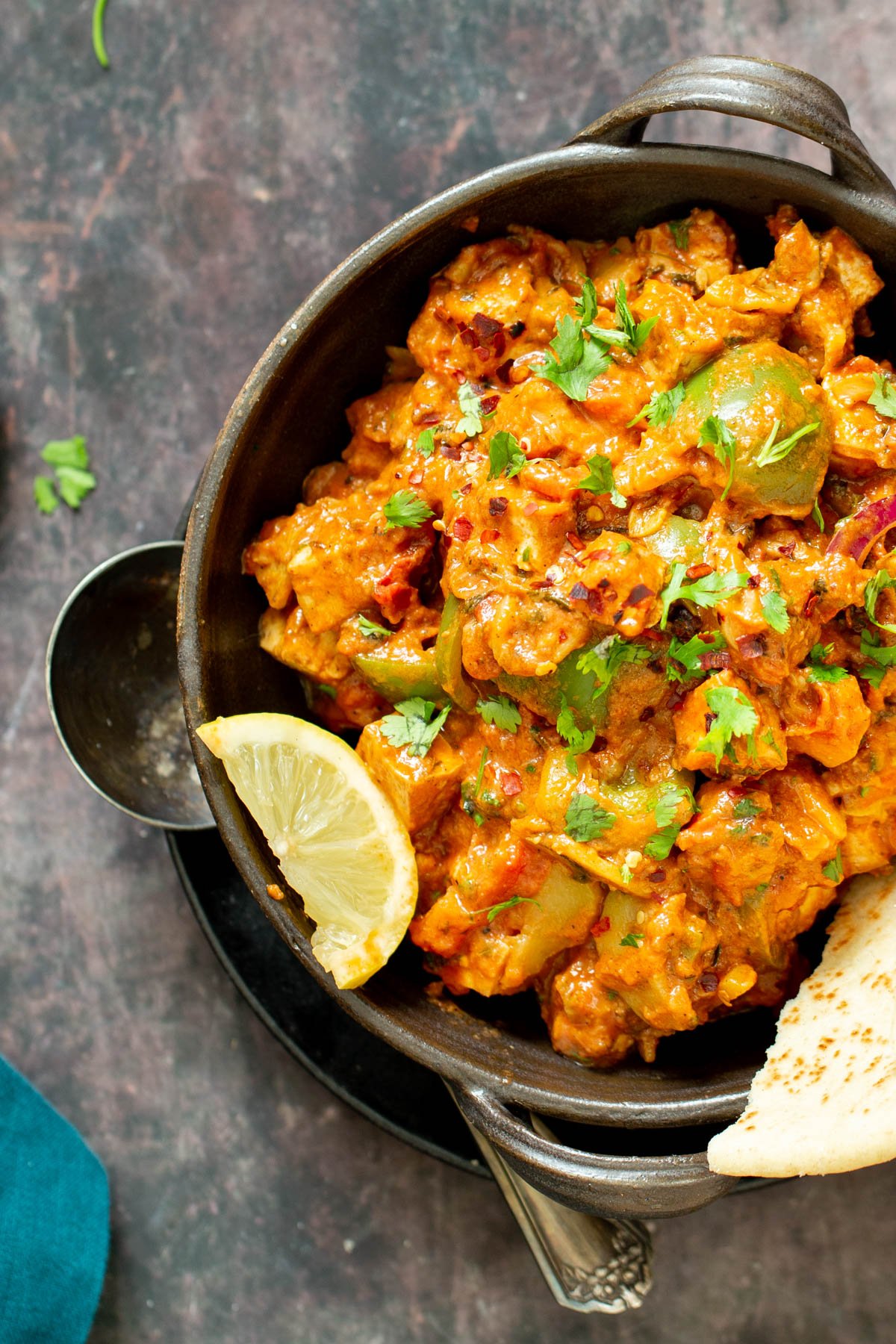Indian tofu tikka masala served with lime wedges and flatbread