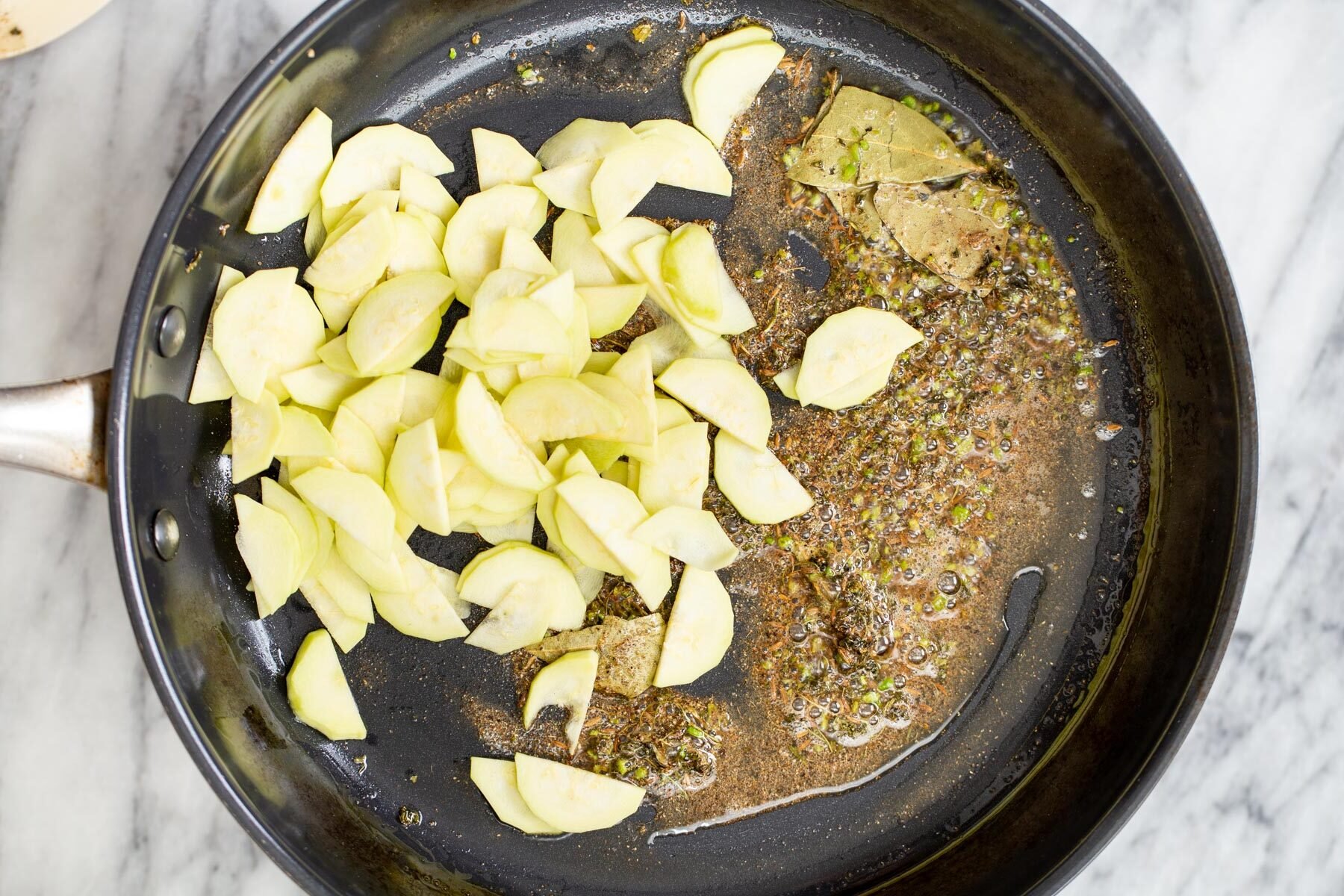 sliced zucchini being added to tempering