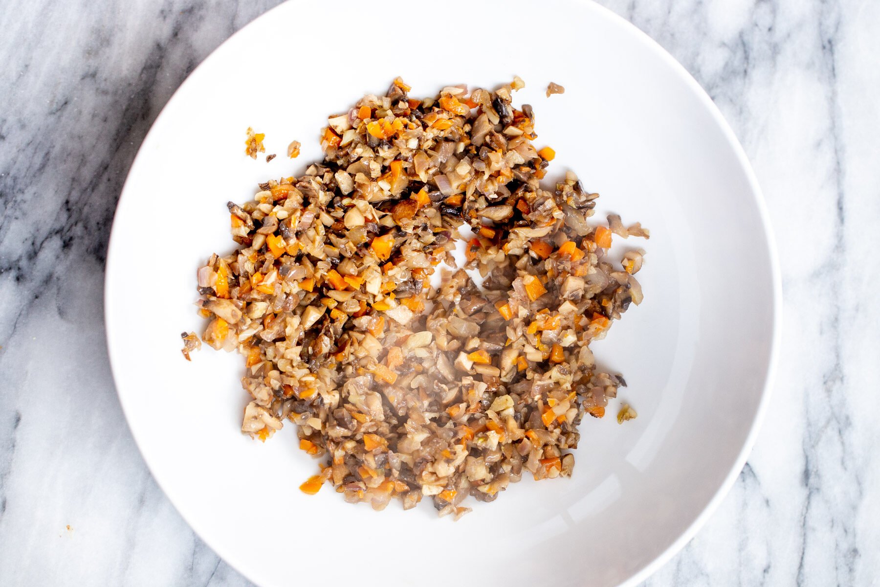 sauteed mushrooms and carrots in a sauteeing pan
