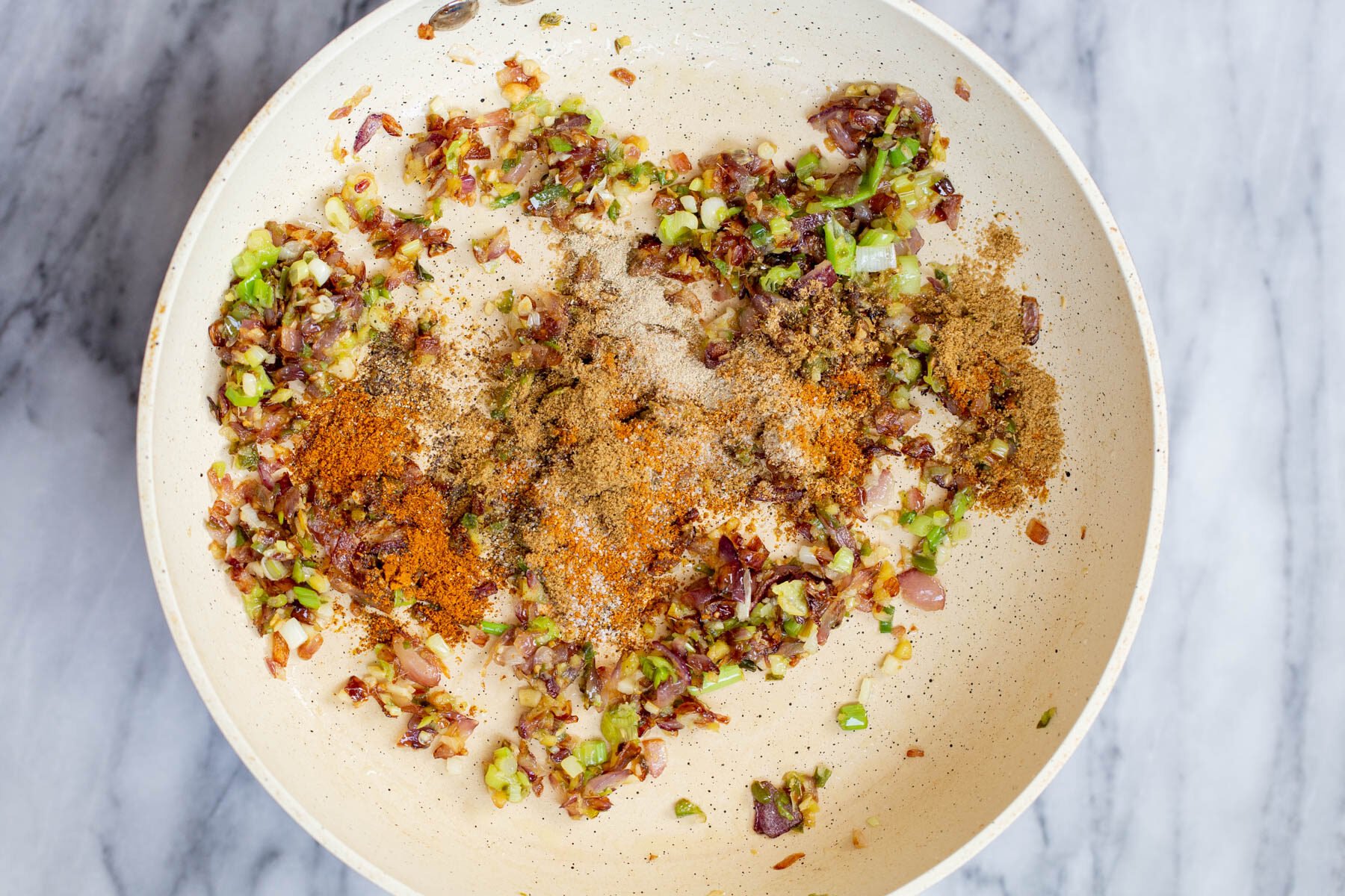 spices being added to vegan lentil filling to make vegan sambusa pie