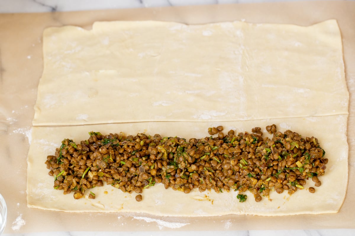 cold lentils being added to vegan puff pastry