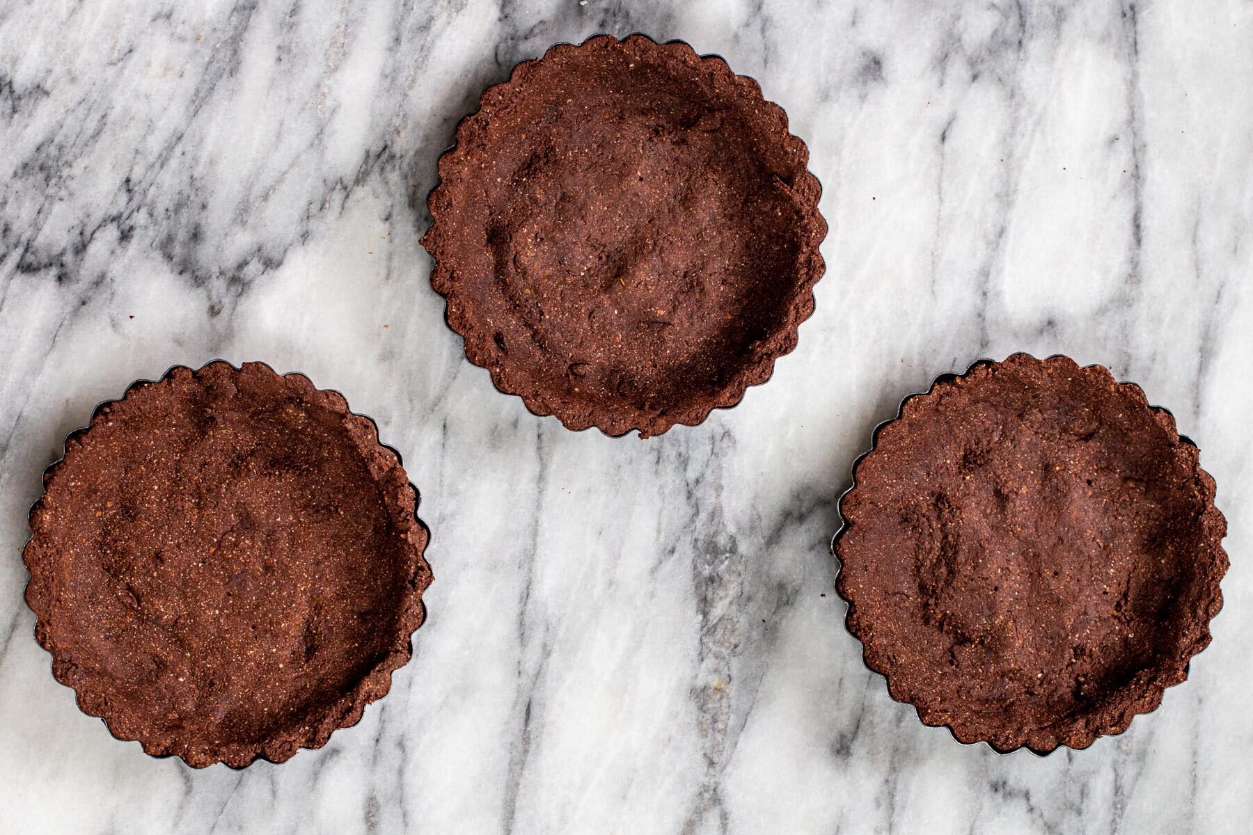 chocolate tartshells on a marble countertop 