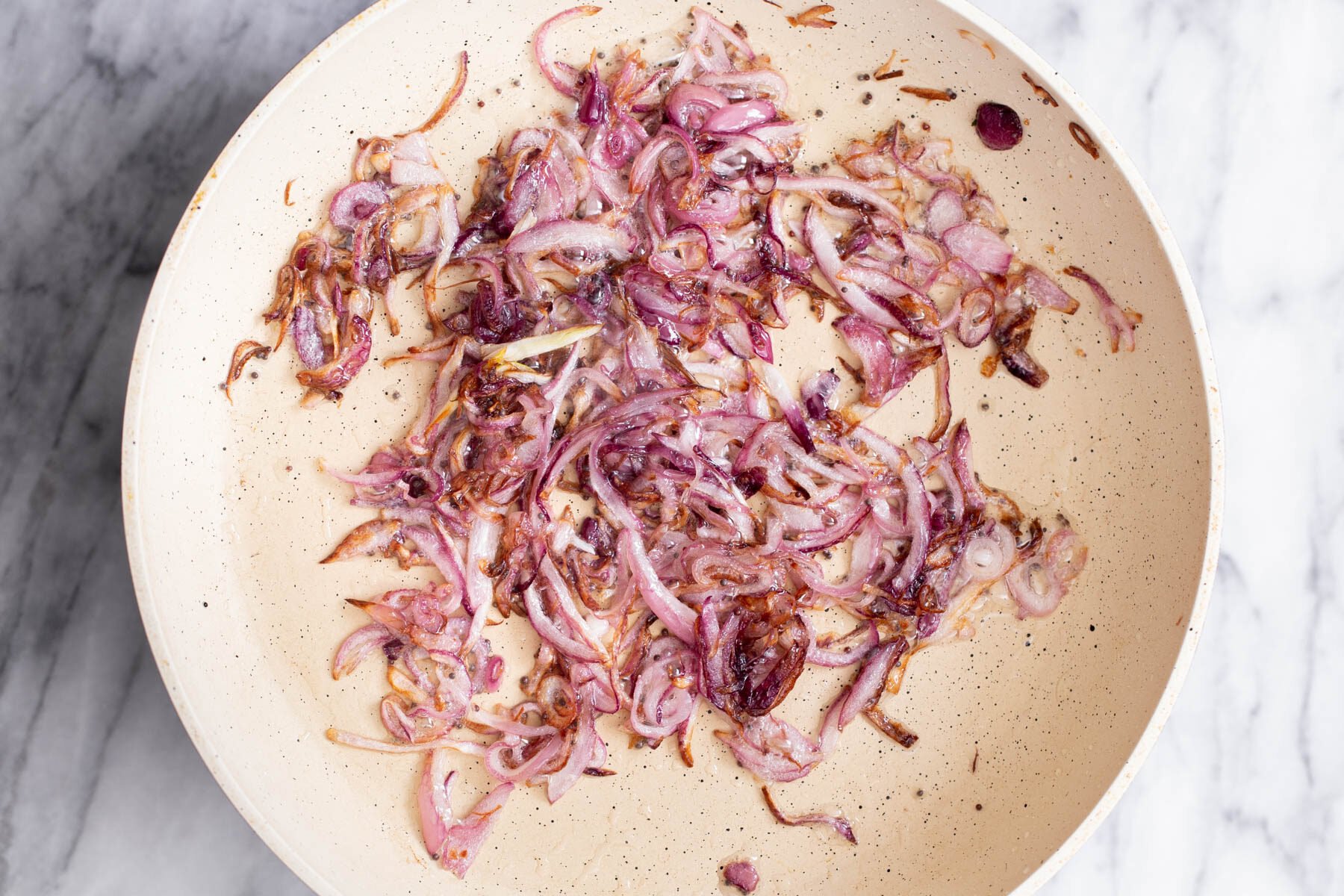 golden brown sauteed onions in a white pan