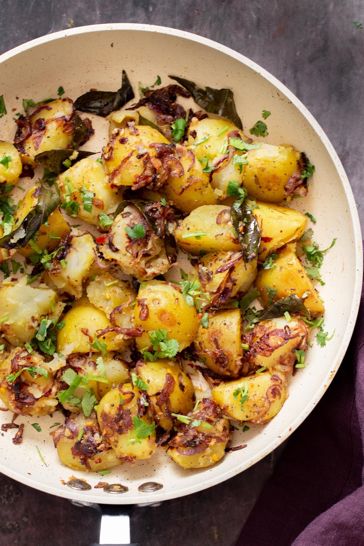 overhead shot of a pan with pan-fried potatoes and onion sprinkled with cilantro