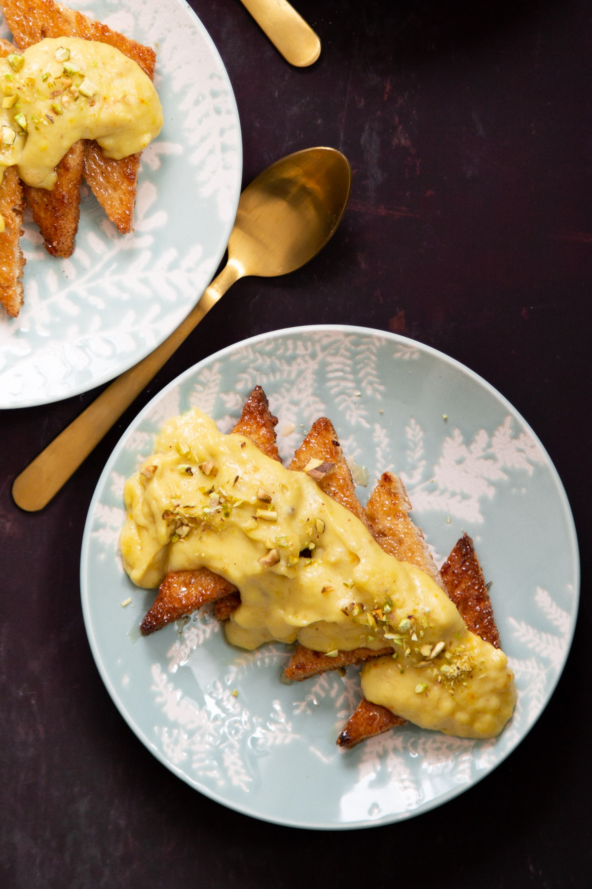 sliced Shahi Tukda brushed with cardamom syrup and topped with custard and sprinkled with pistachio