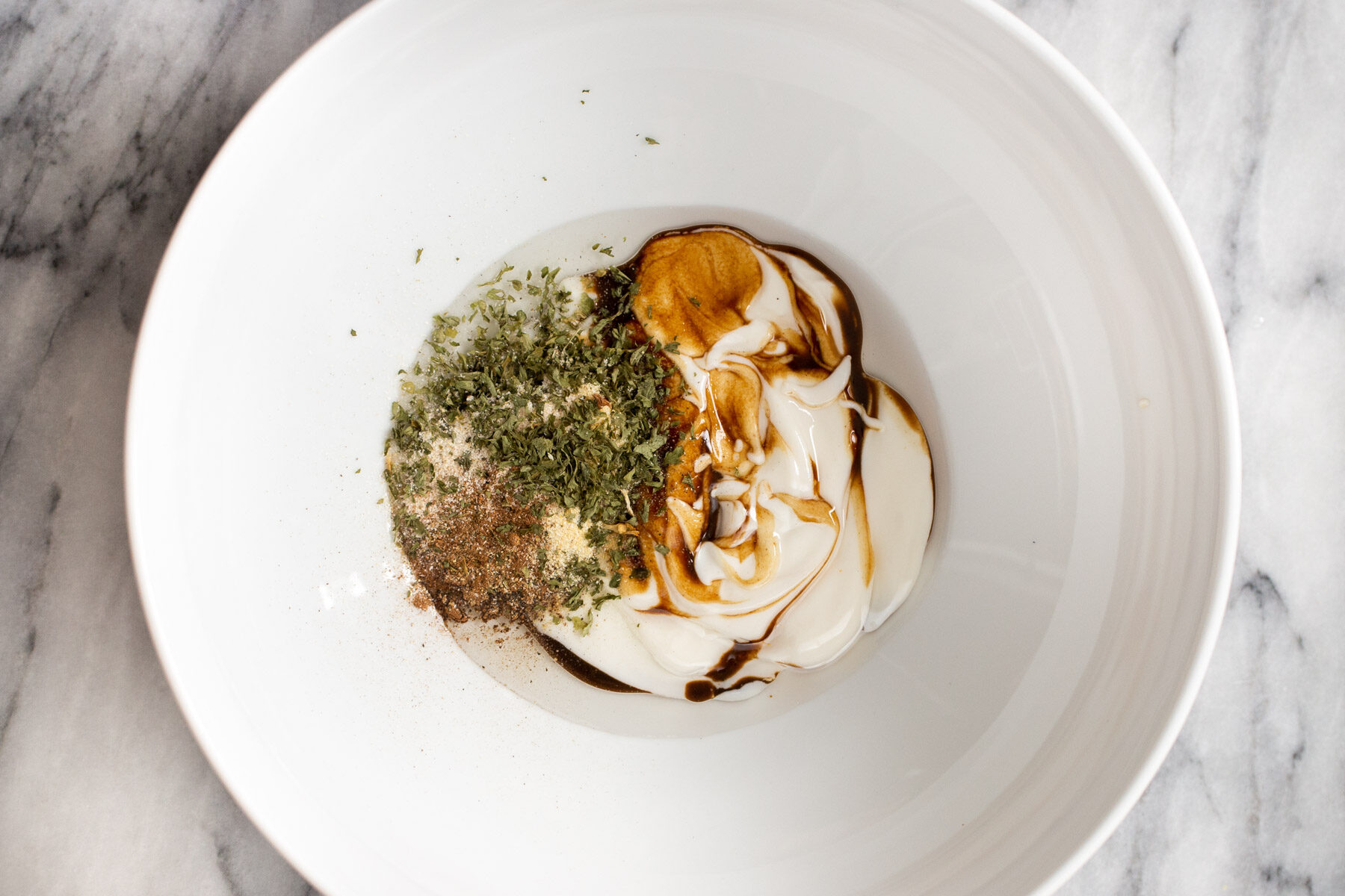 yogurt being mixed with seasoning to make vegan marinade