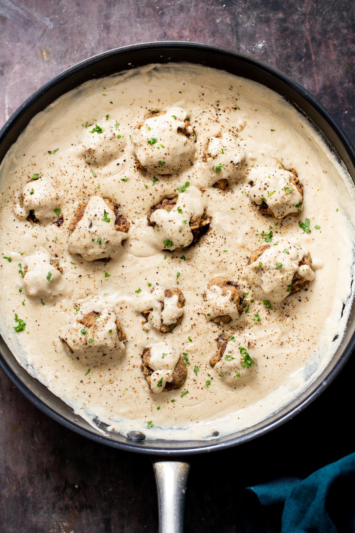 vegan mushroom balls in vegan mushroom gravy in a black saucepan
