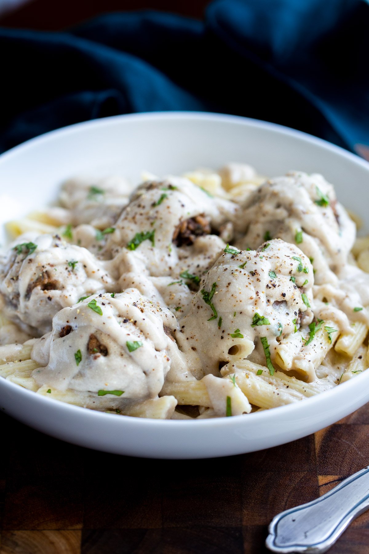 a plate of vegan swedish meatballs served over pasta