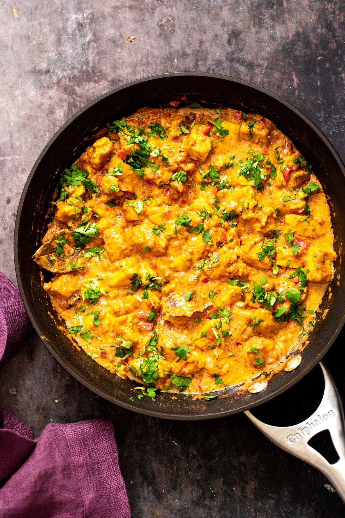 a skillet with vegan rogan josh sprinkled with cilantro 