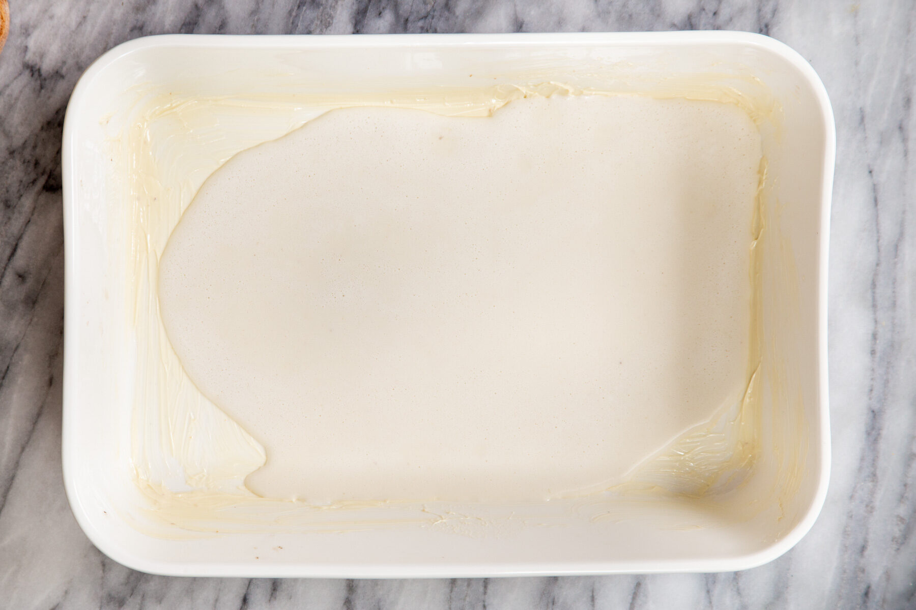 vegan cashew custard being poured into a casserole dish to make baked French toast