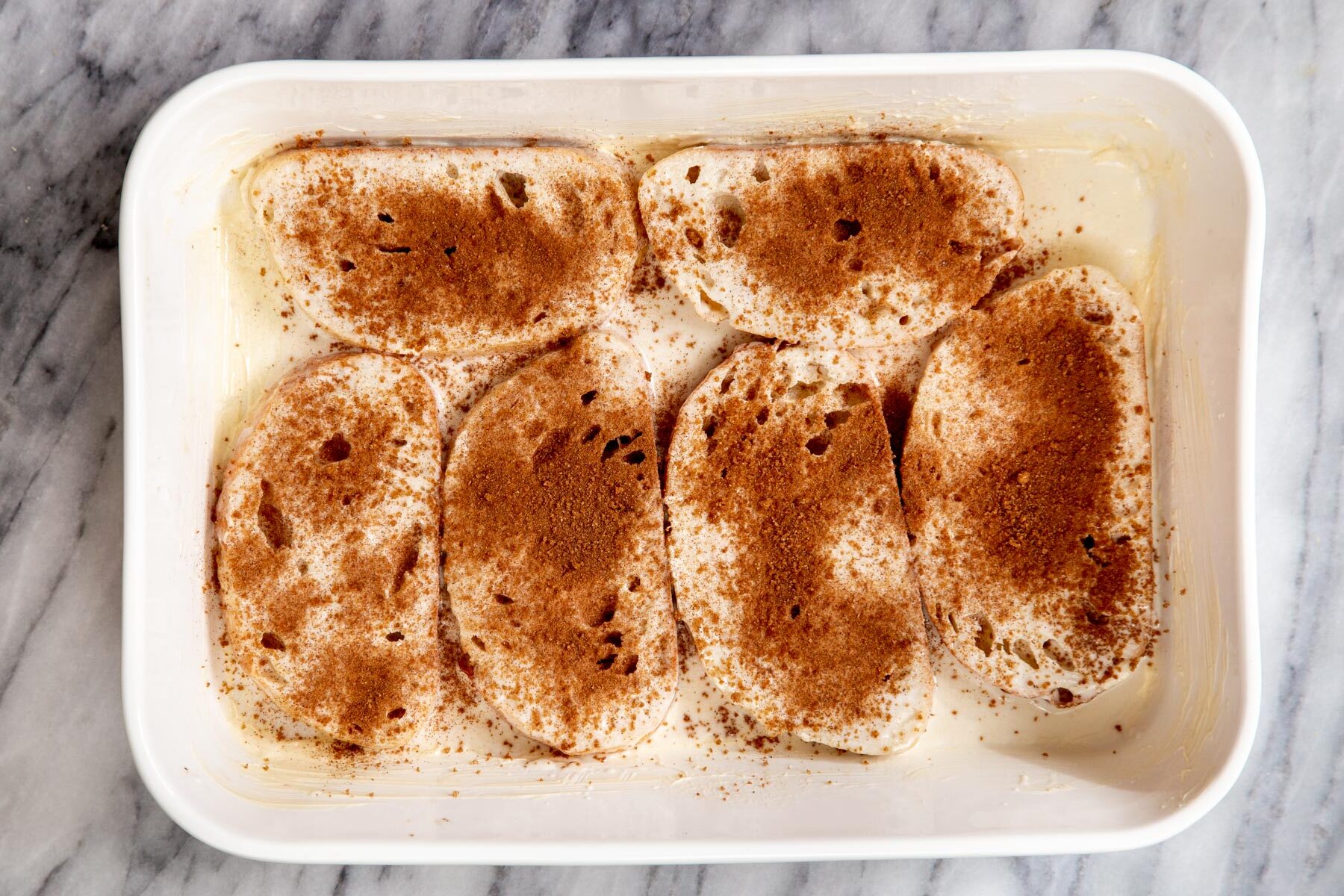 cinnamon and sugar being sprinkled over vegan french toast casserole