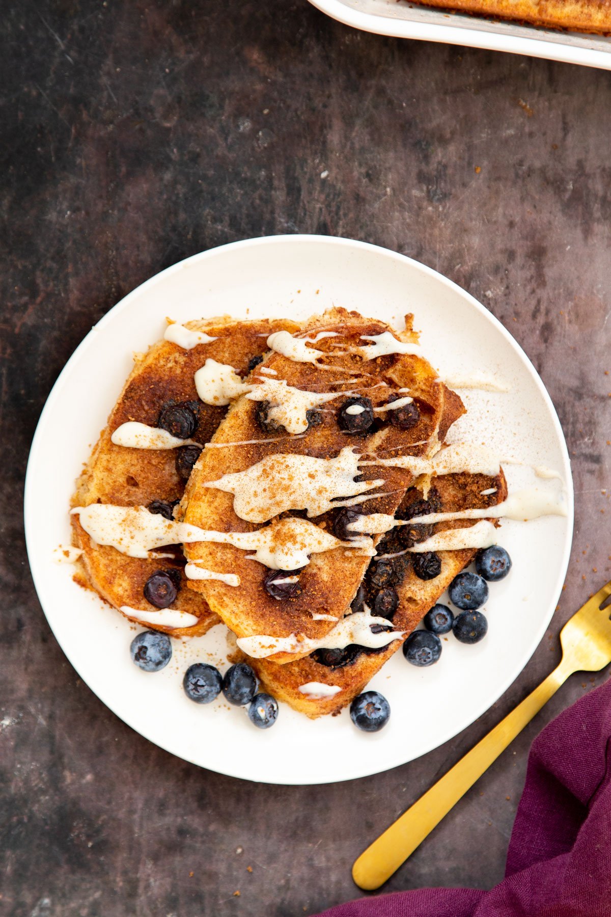 vegan French Toast on a plate served with blueberries and a cashew custard drizzle