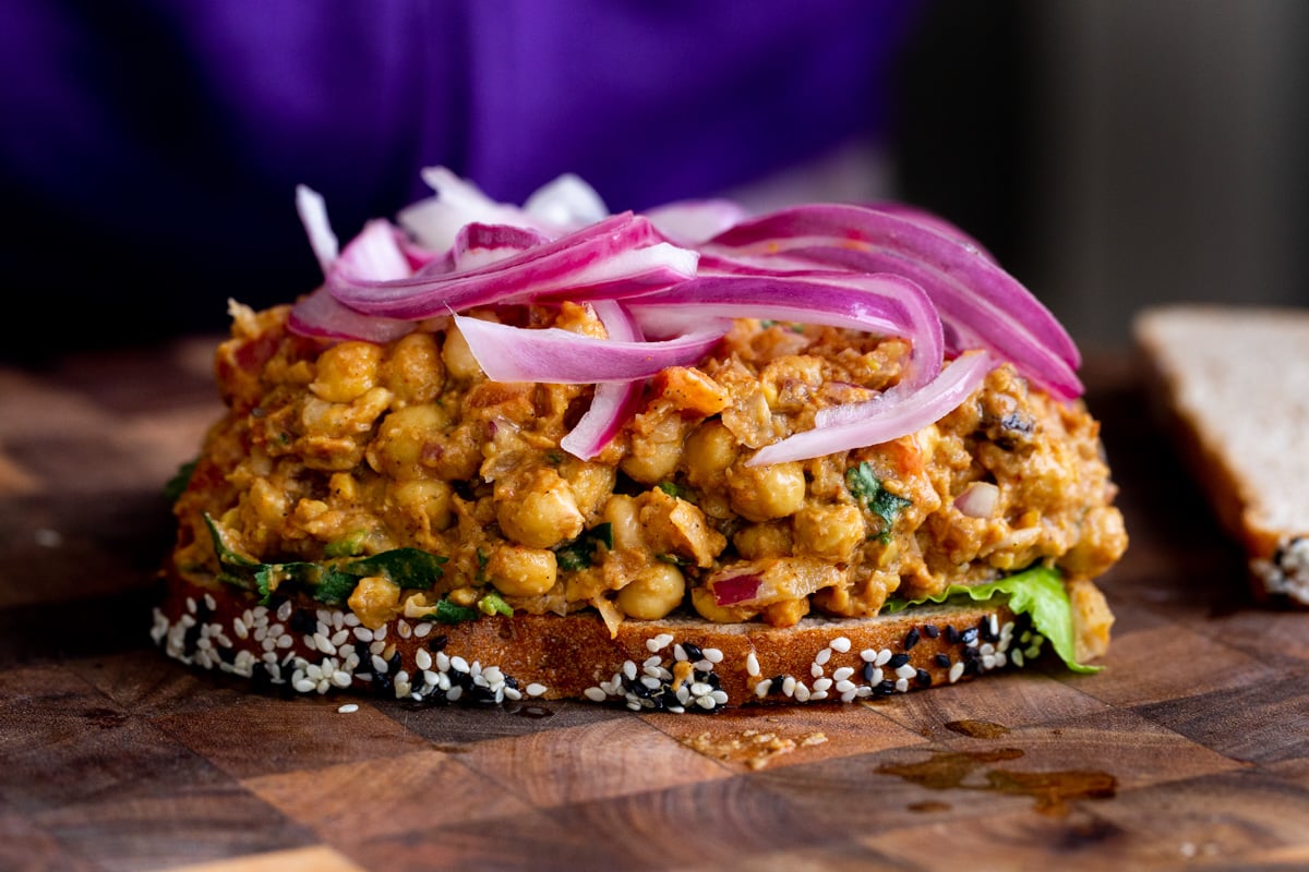curried chickpea salad and quick pickled onions on a slice of bread