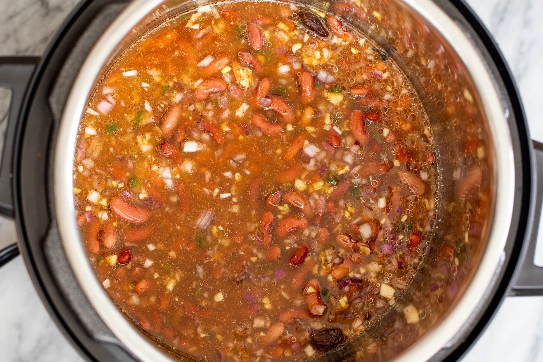 red kidney beans cooking with onion and tomato paste in an instant pot