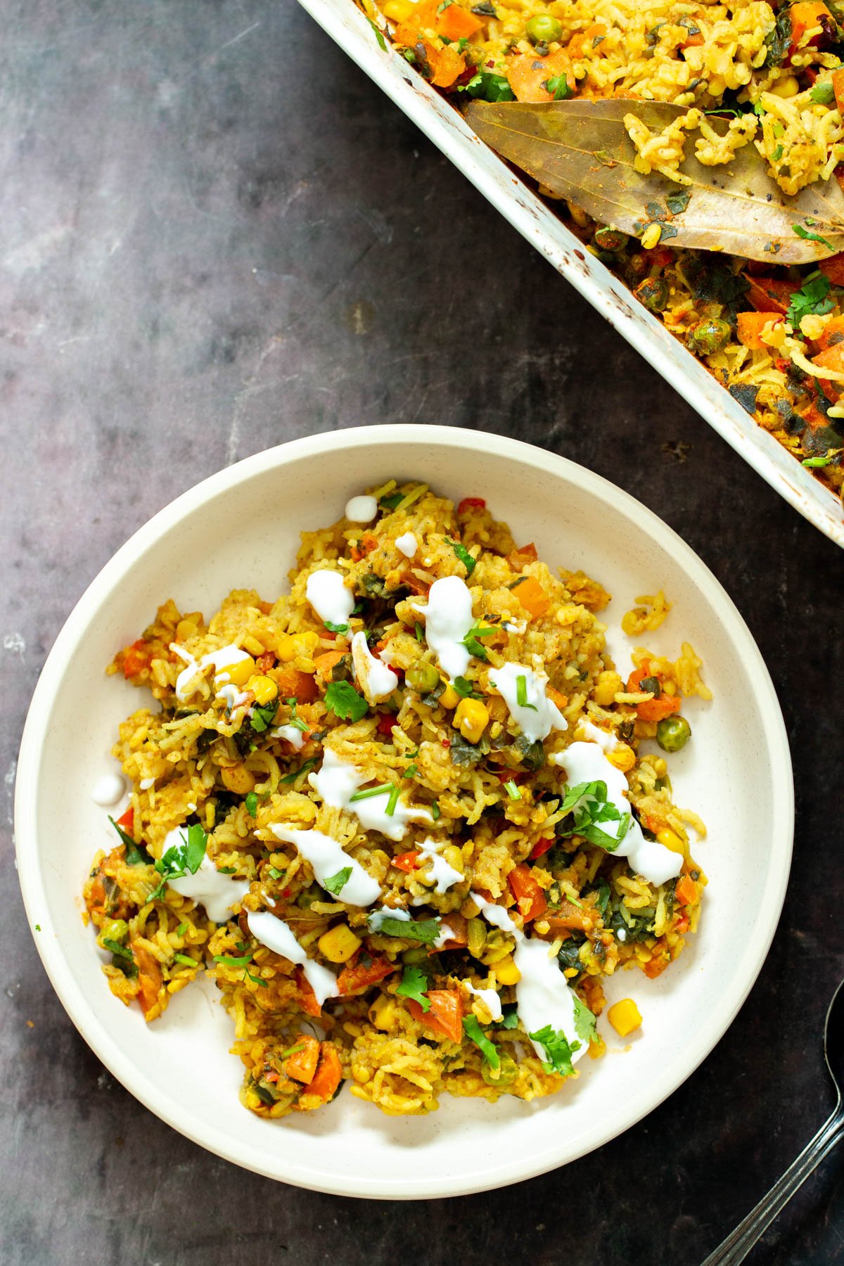a plate with vegan lentil rice casserole served drizzled with yogurt