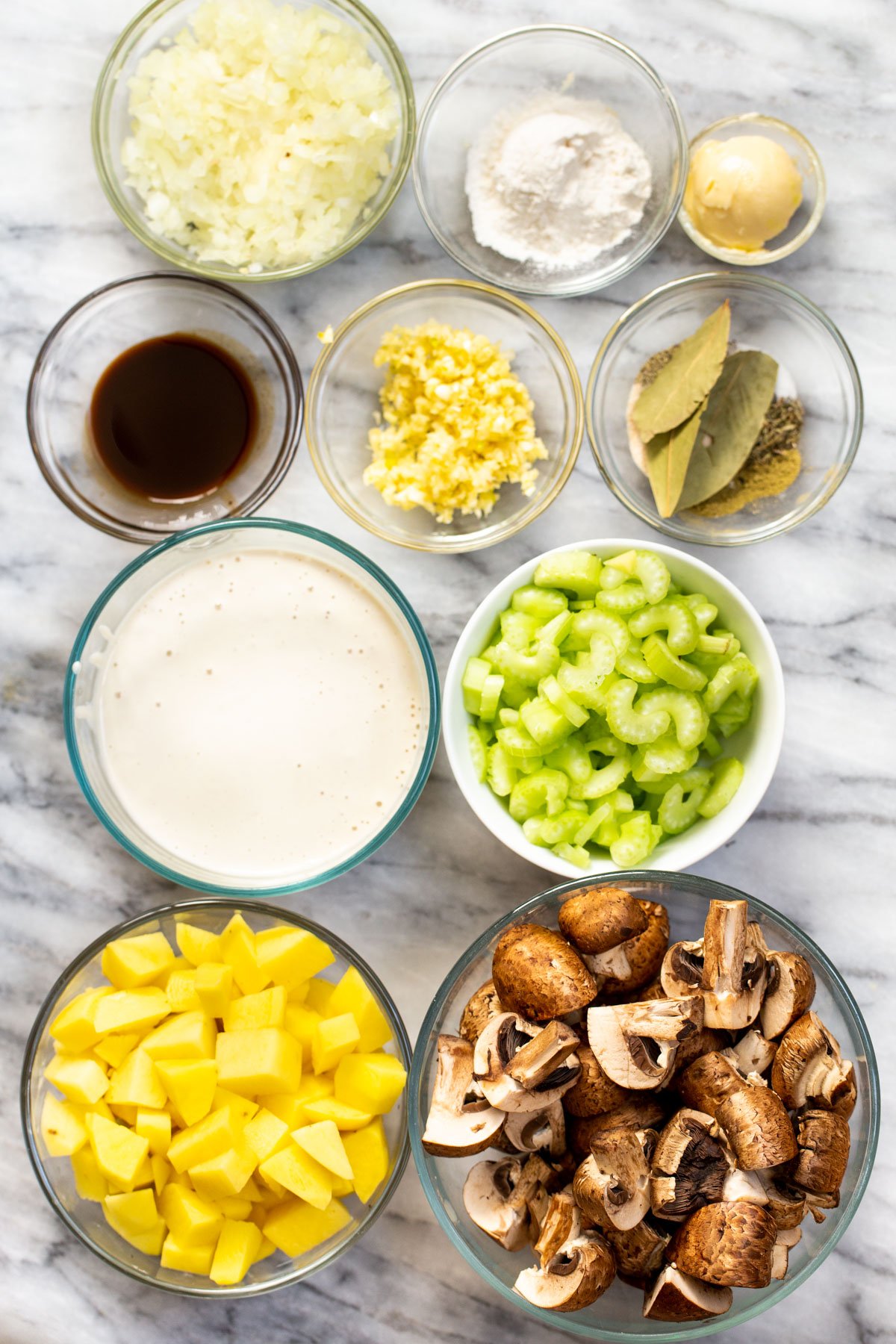 ingredients needed for making vegan mushroom chowder on a marble slate