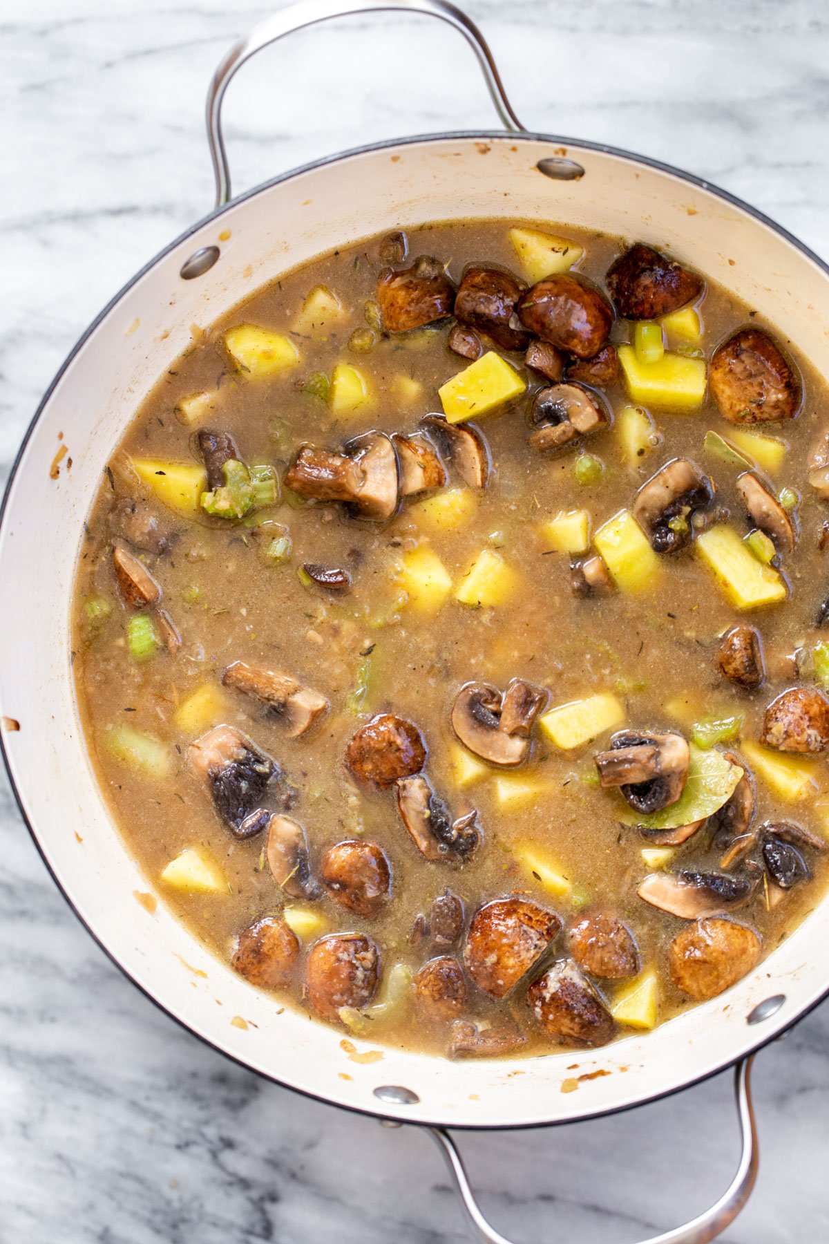 a pot with vegan mushroom chowder on a marble slate