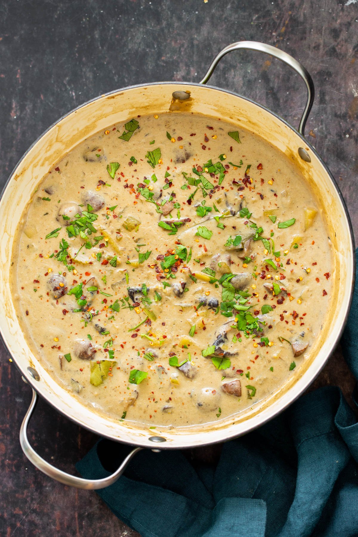 a pot of creamy vegan mushroom chowder sprinkled with fresh herbs