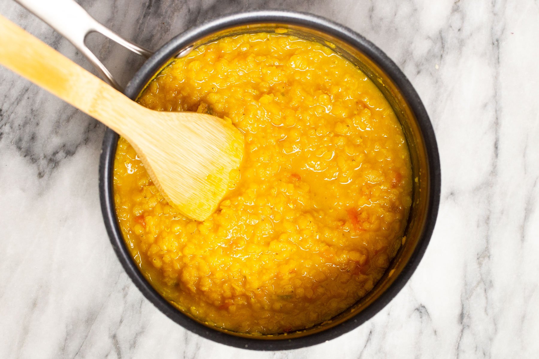 red lentils being cooked in a pot 