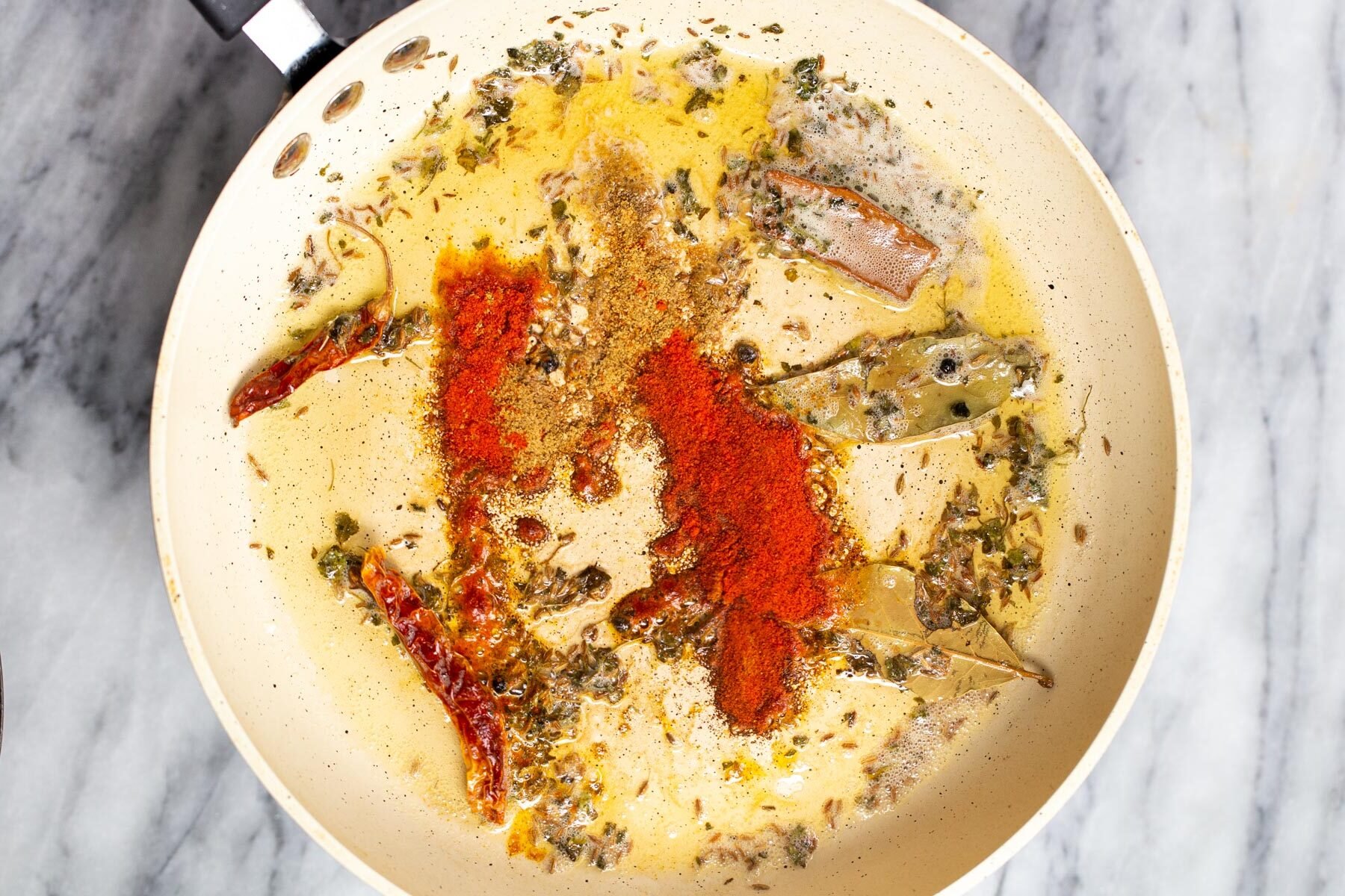 ground spices being added to tempering for dal recipe