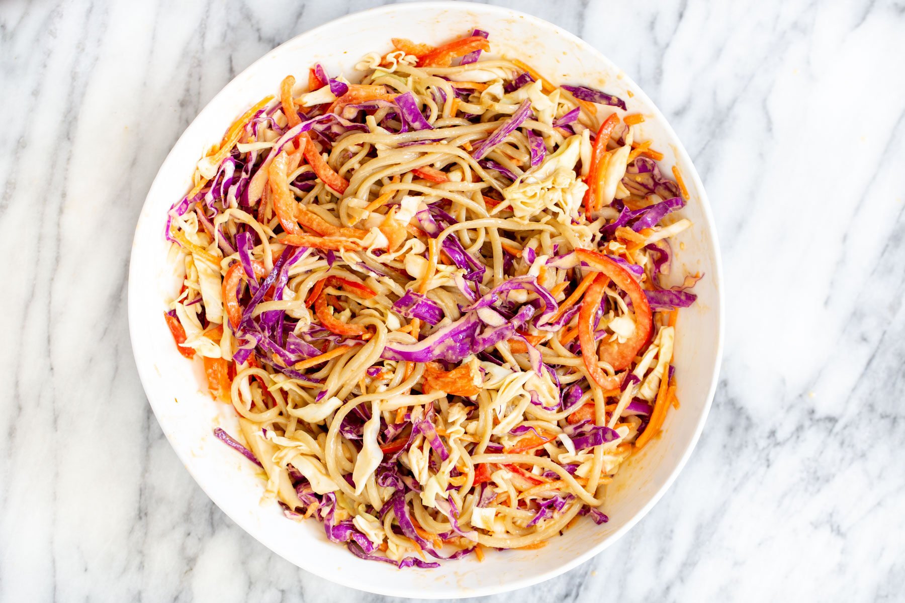 a white bowl with peanut sesame noodle salad