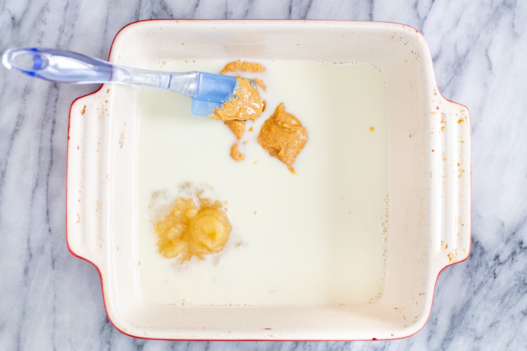 a casserole dish with applesauce, peanut butter and hot milk