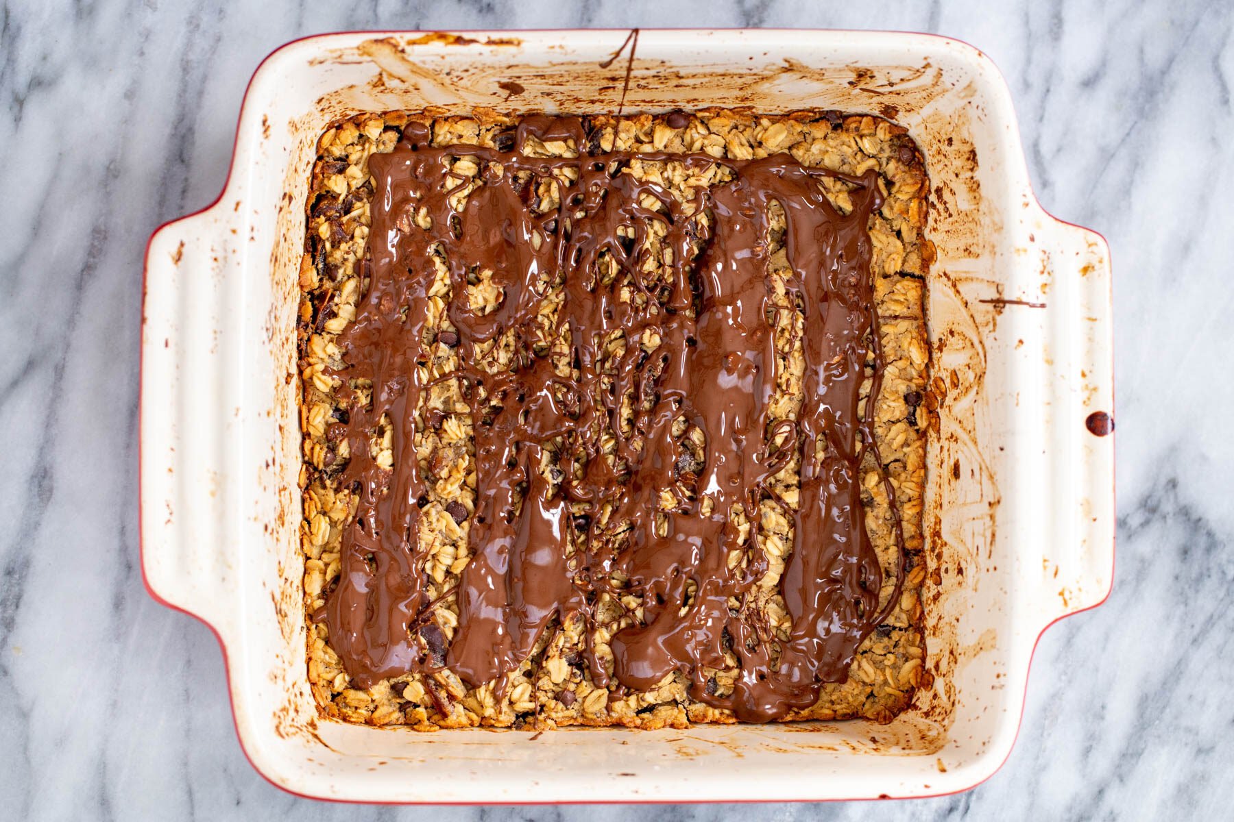 peanut a casserole dish with peanut butter baked oatmeal drizzled with melted chocolate