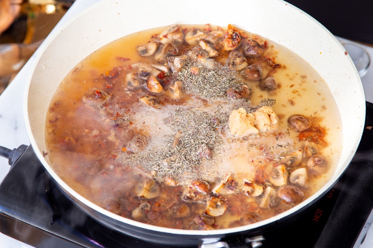 mushrooms cooking in sun-dried tomato sauce