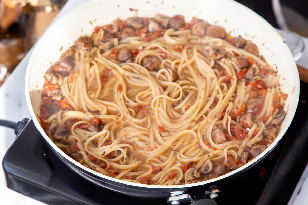 freshly cooked sundried tomato mushroom pasta in a saucepan