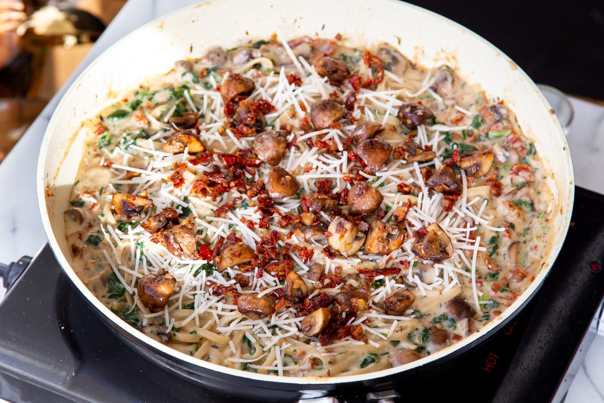 mushroom spinach and sundried tomato pasta in a saucepan